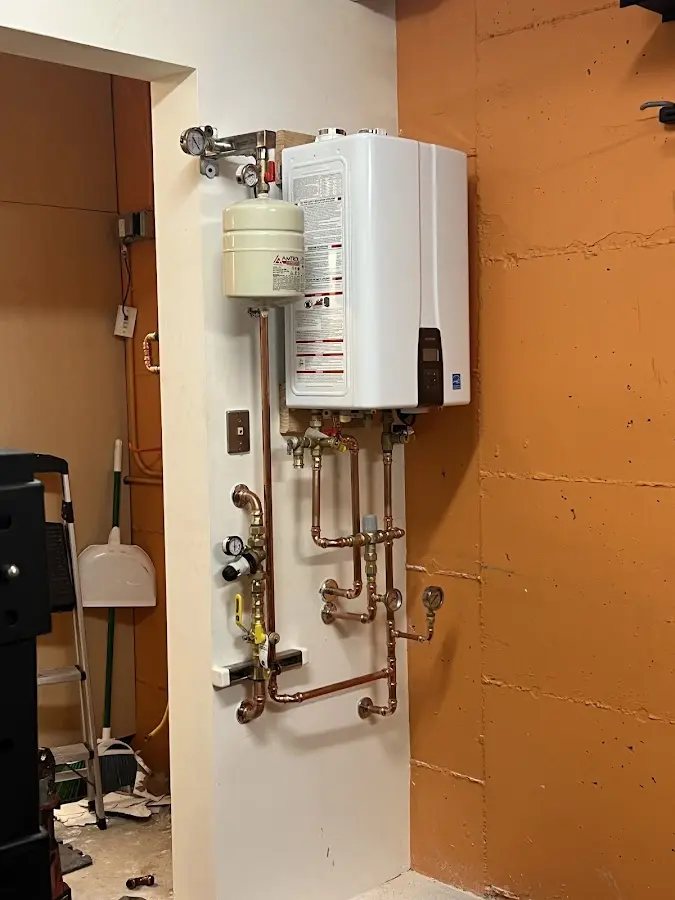 Plumbing technician inspecting water heater connections in Elyria